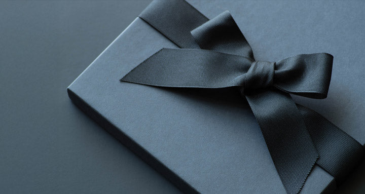 Dark blue gift box with a bow on a matching background