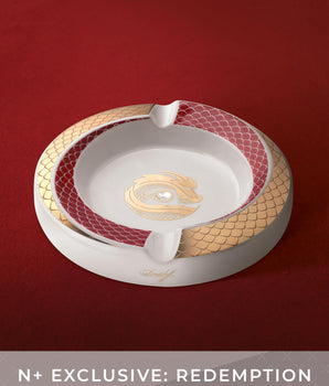 Decorative ashtray with gold and red accents on a red background