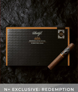 Cigar box with a cigar on a dark textured background