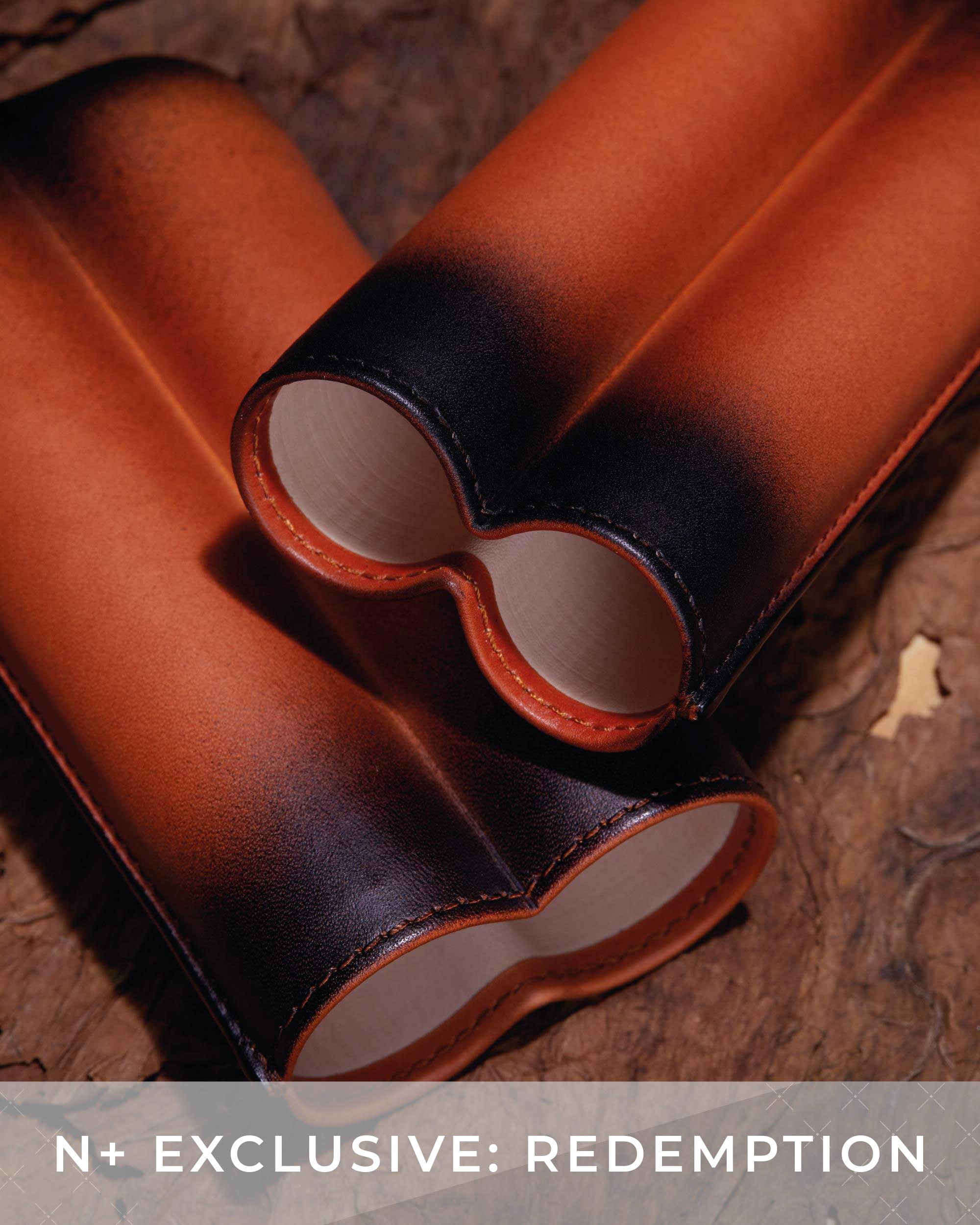 Brown leather binocular case on a wooden surface with 'N+ Exclusive: Redemption' text.