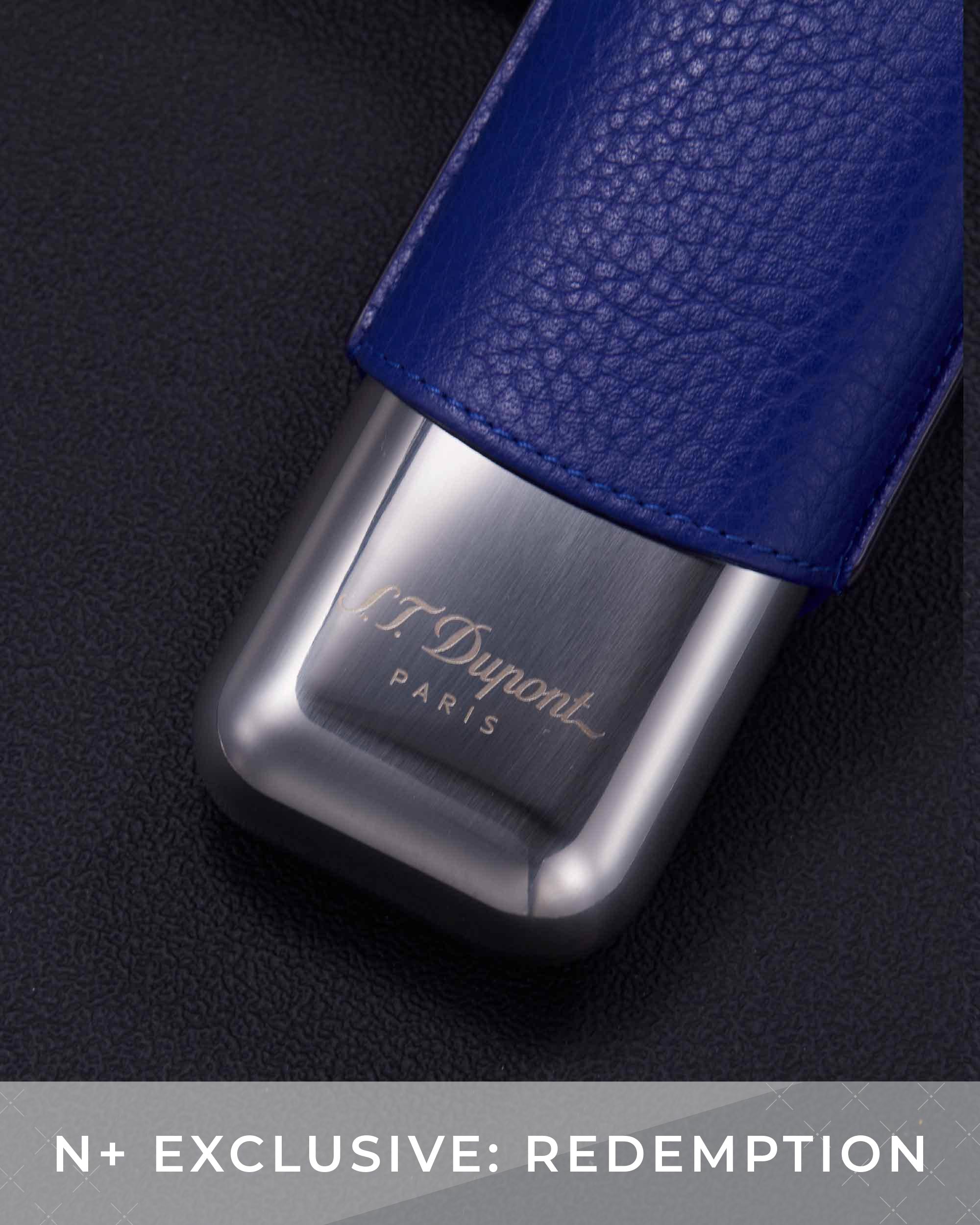 Blue leather and silver metal vape device with T. Dupont branding on a dark background