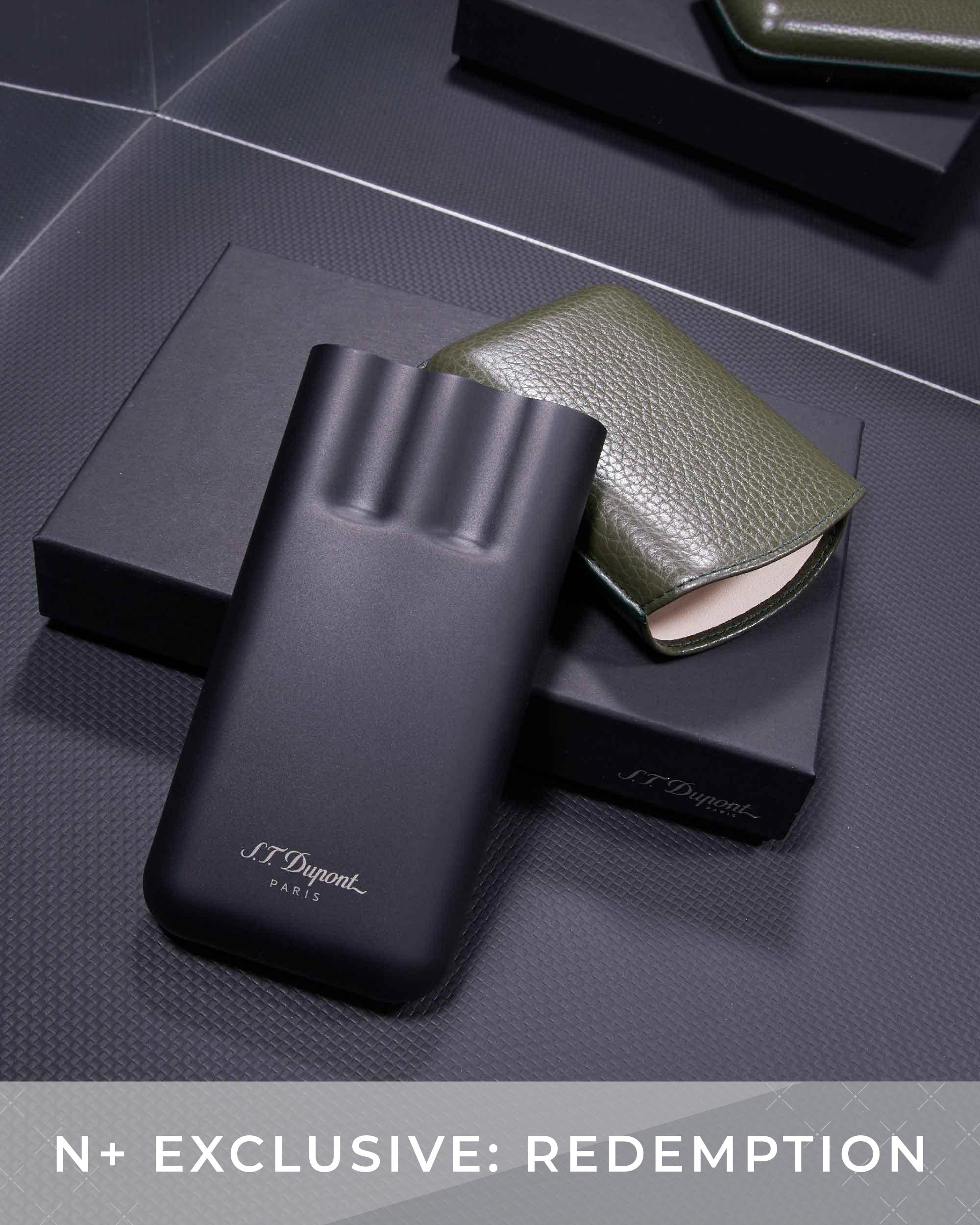 Black and green S.T. Dupont products on a dark textured surface with 'N+ Exclusive: Redemption' text.