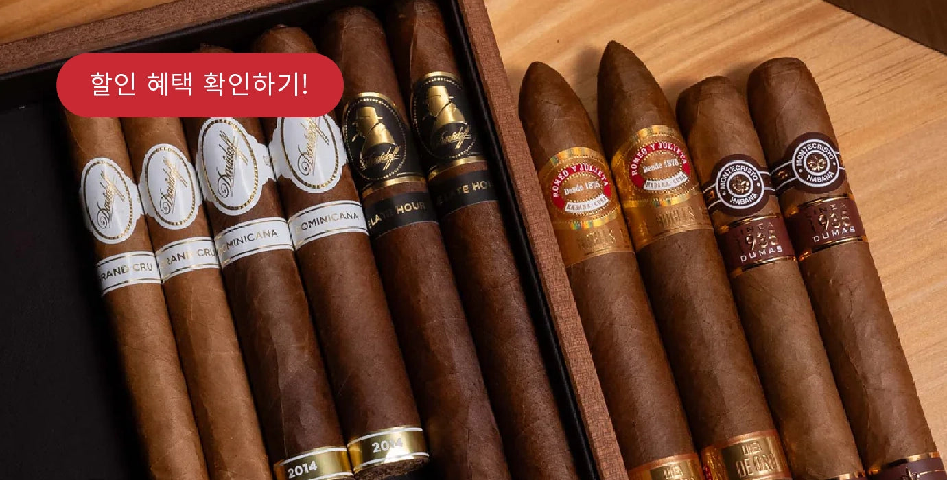 Assorted cigars in a wooden humidor with visible brand labels.
