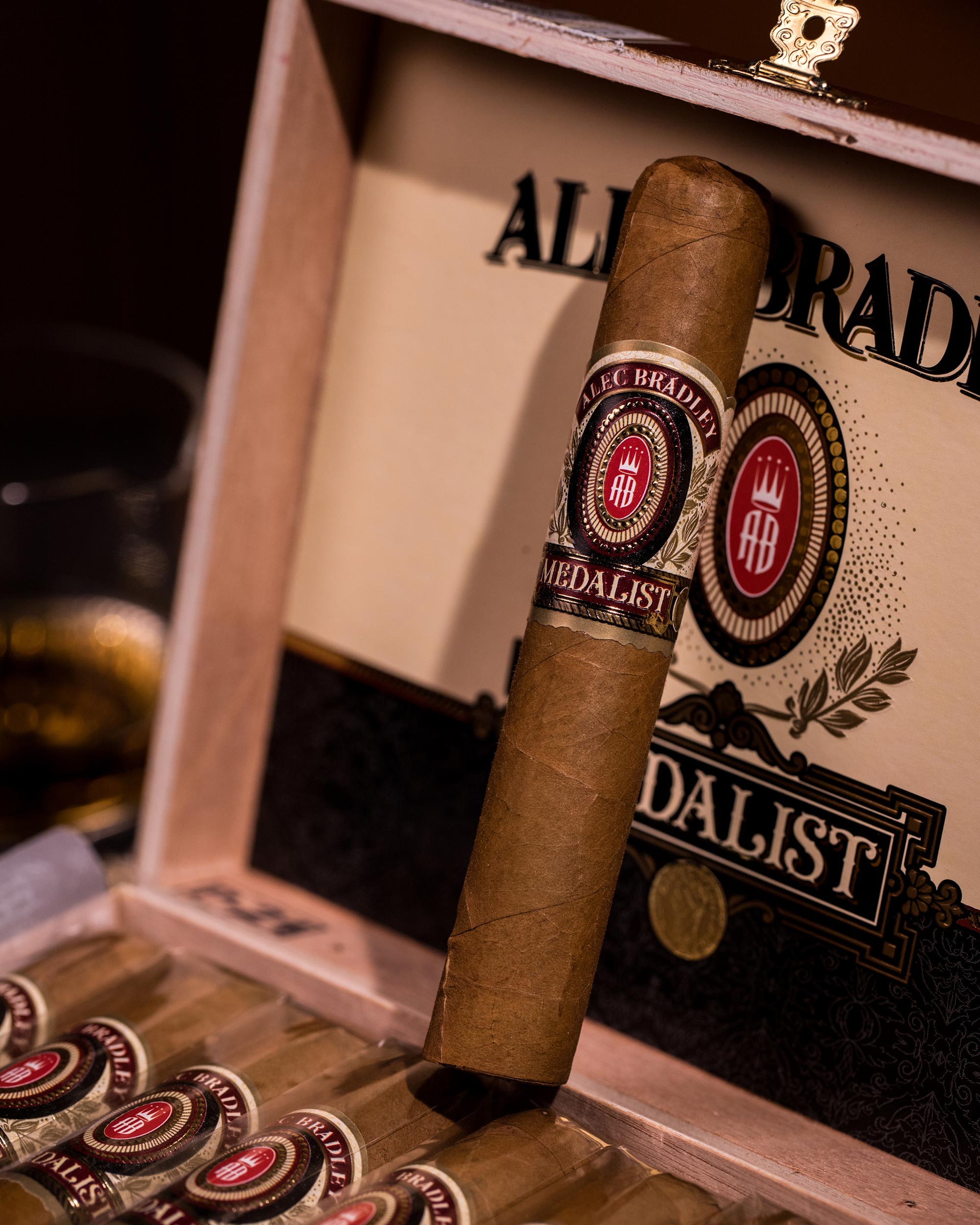Cigar with Medallist label on a wooden tray in front of an Alfredo Bradda branded box.