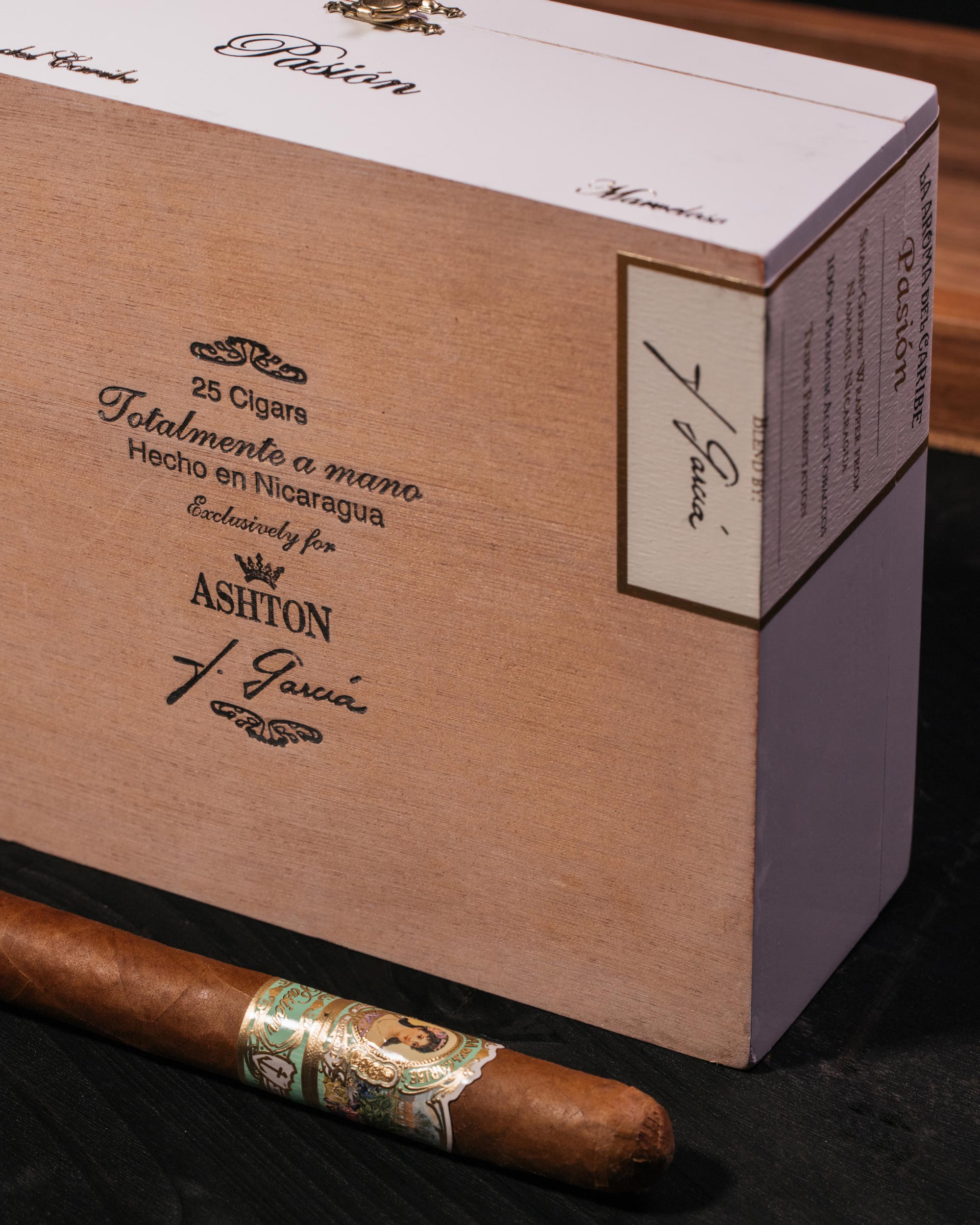 Cigar box with a cigar on a dark surface