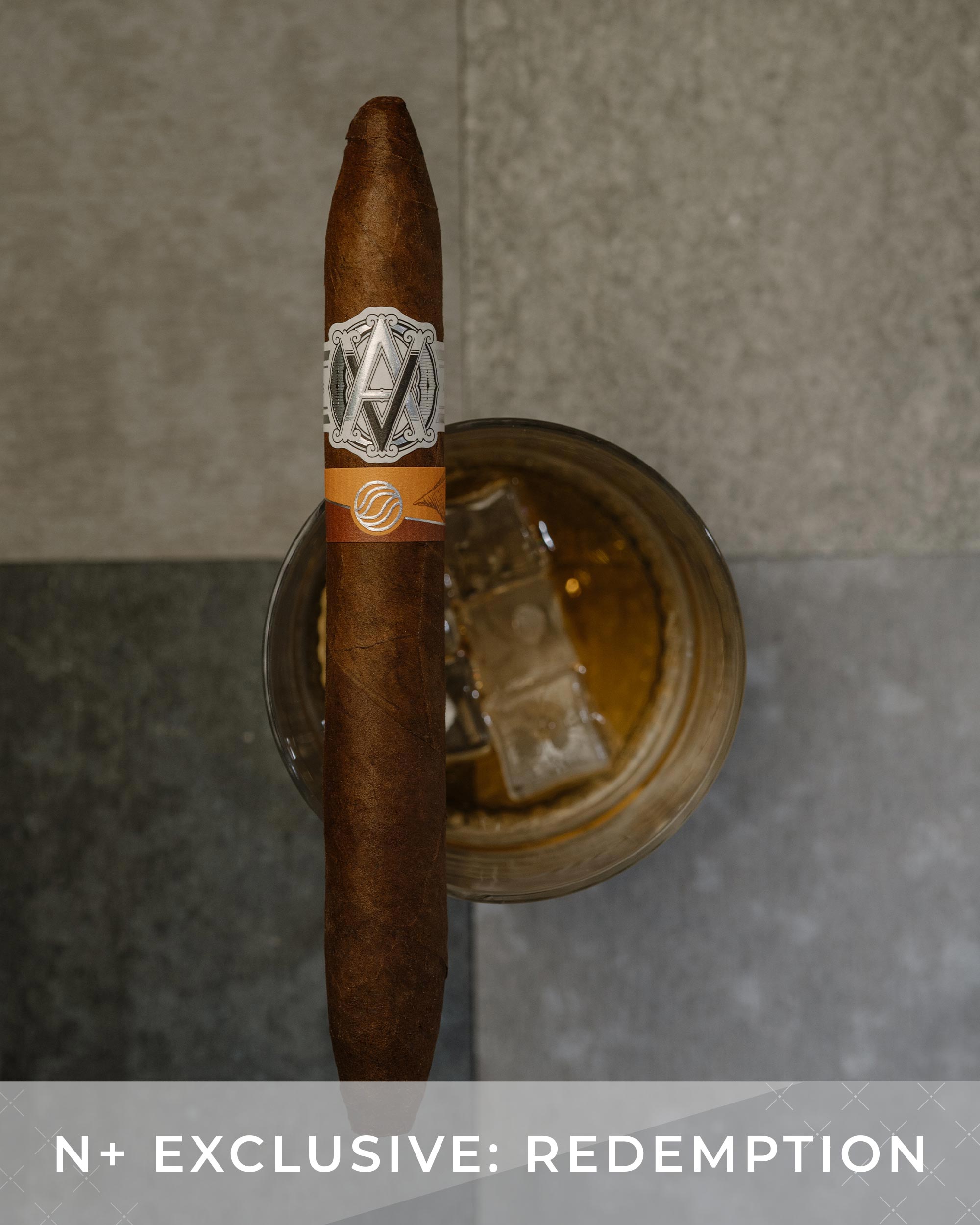 Cigar with a band on a metallic stand against a gray background, featuring 'N+ Exclusive: Redemption' text.