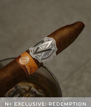 Cigar with a label on a textured surface, featuring the text 'N+ Exclusive: Redemption'.