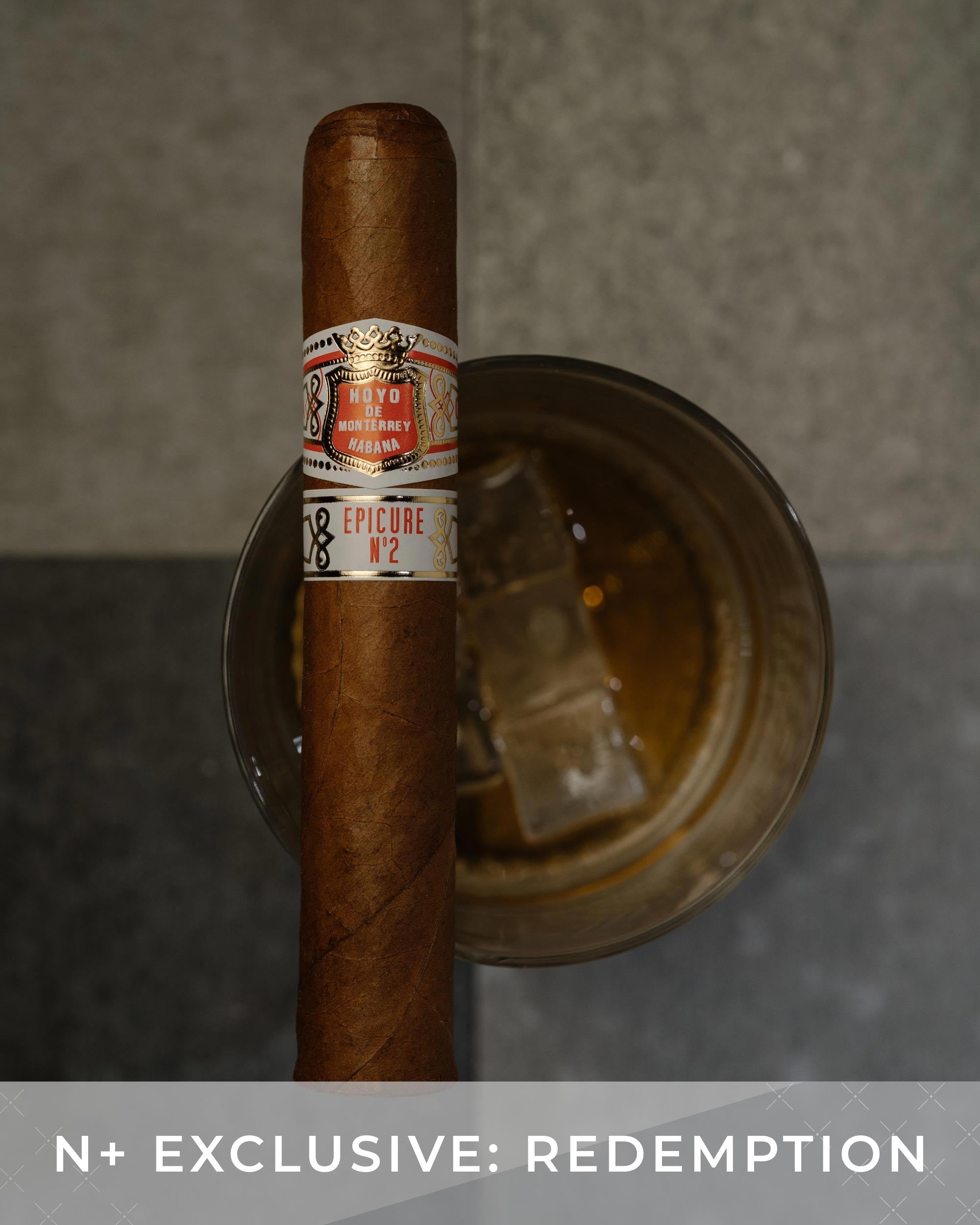 Cigar with a label on a metal stand against a gray background