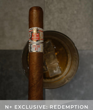 Cigar with a label on a metal stand against a gray background