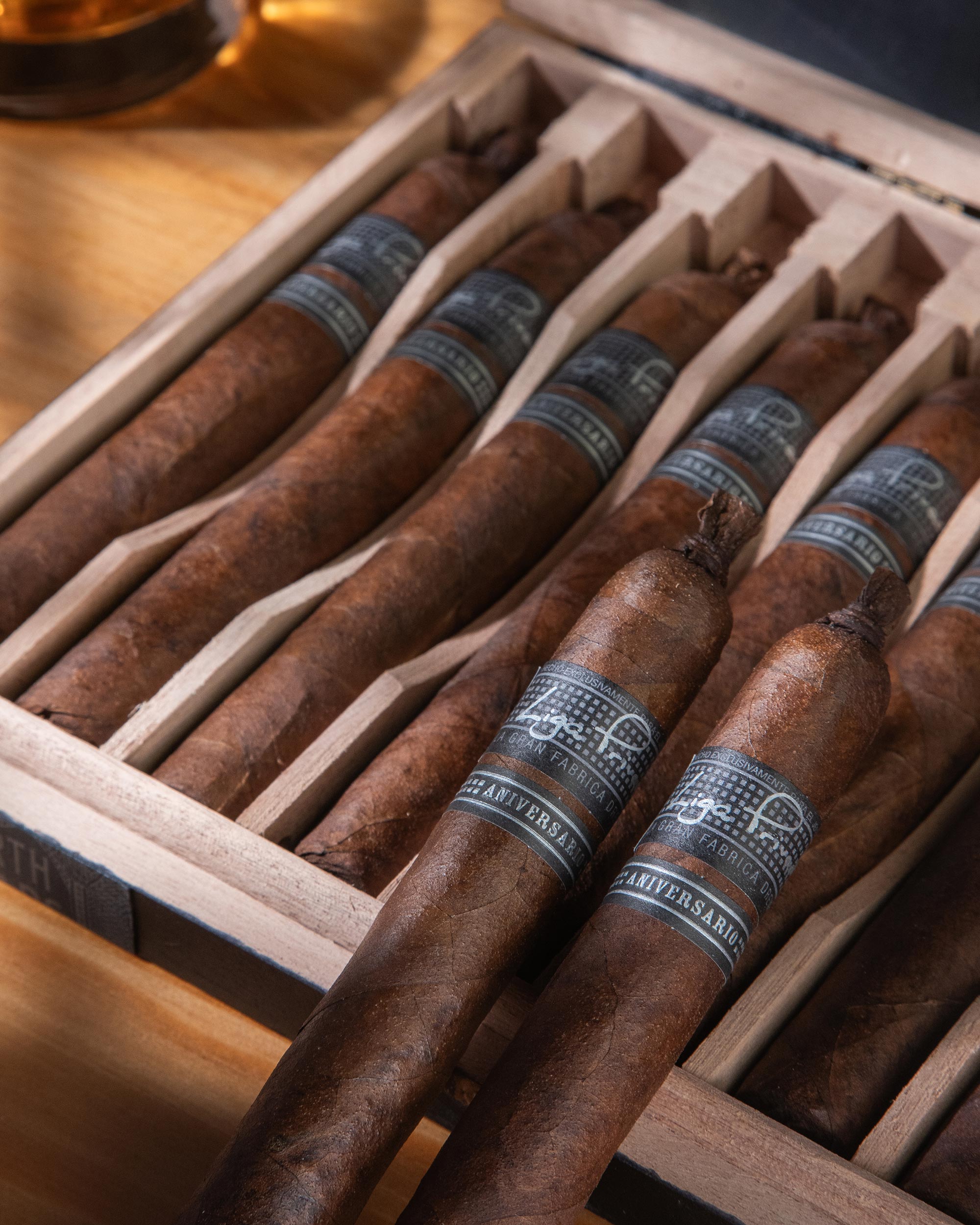Cigars with blue bands in a wooden humidor