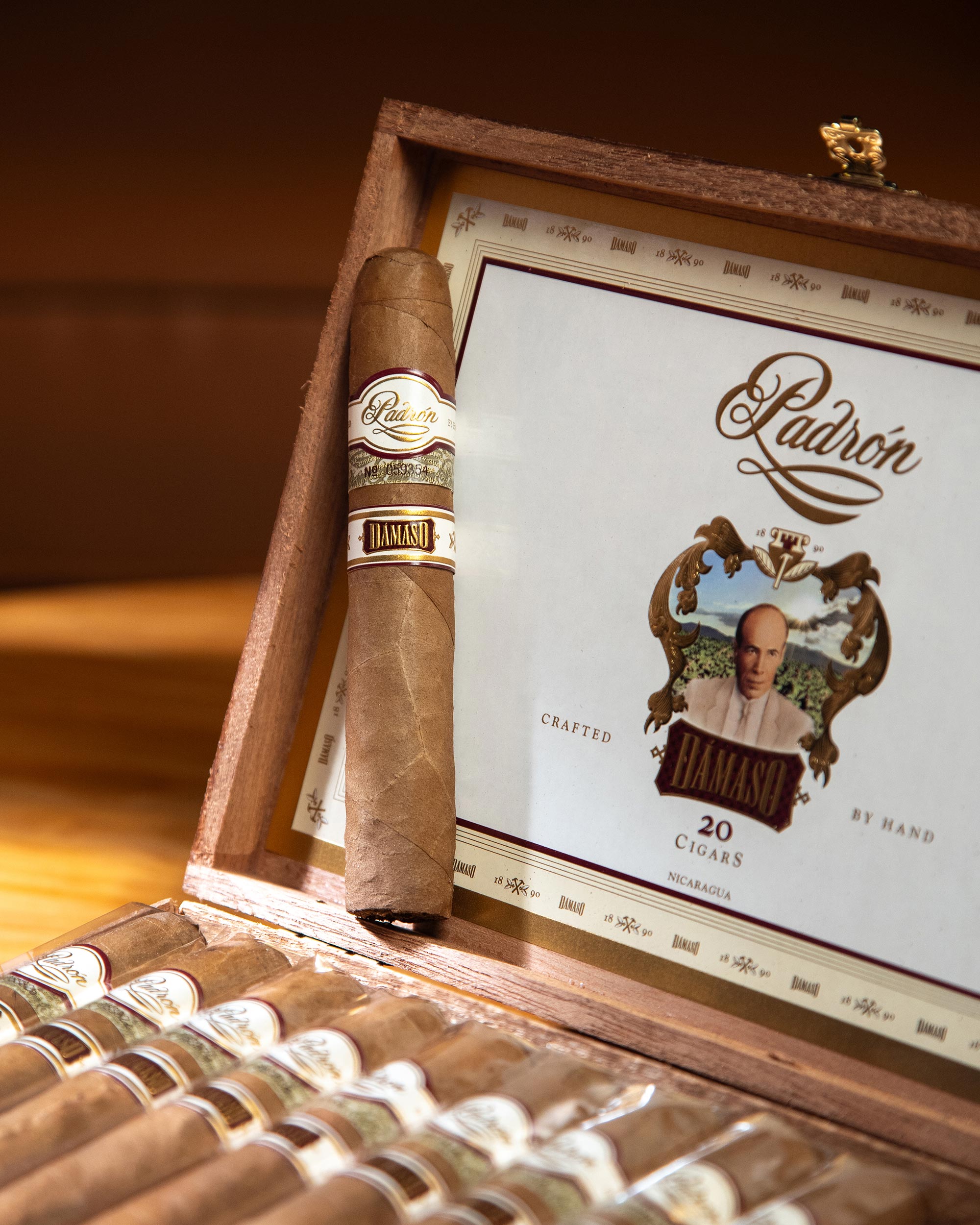 Ládron cigars in a wooden humidor with a close-up of a single cigar and its label.