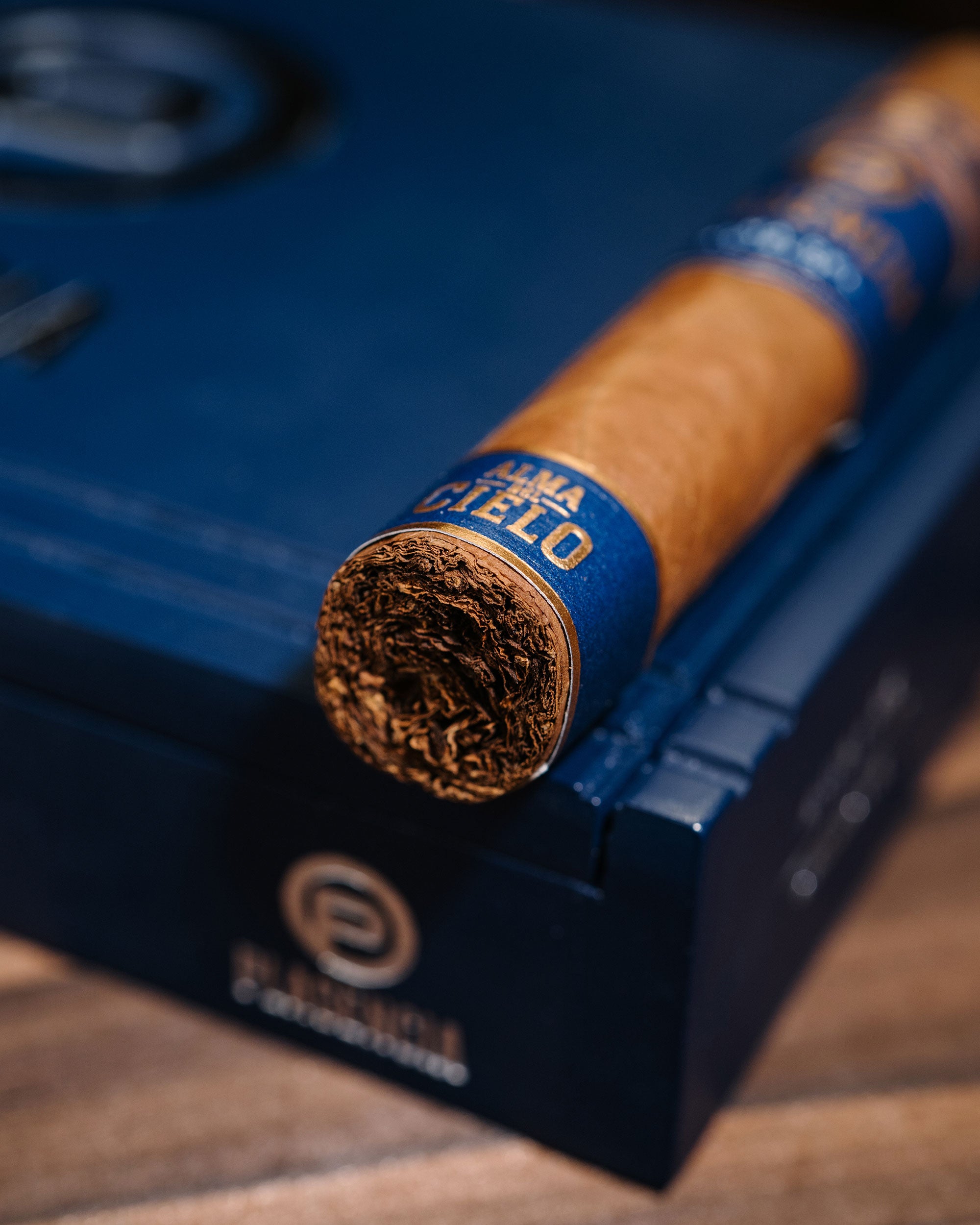 Cigar with blue band on a blue humidor