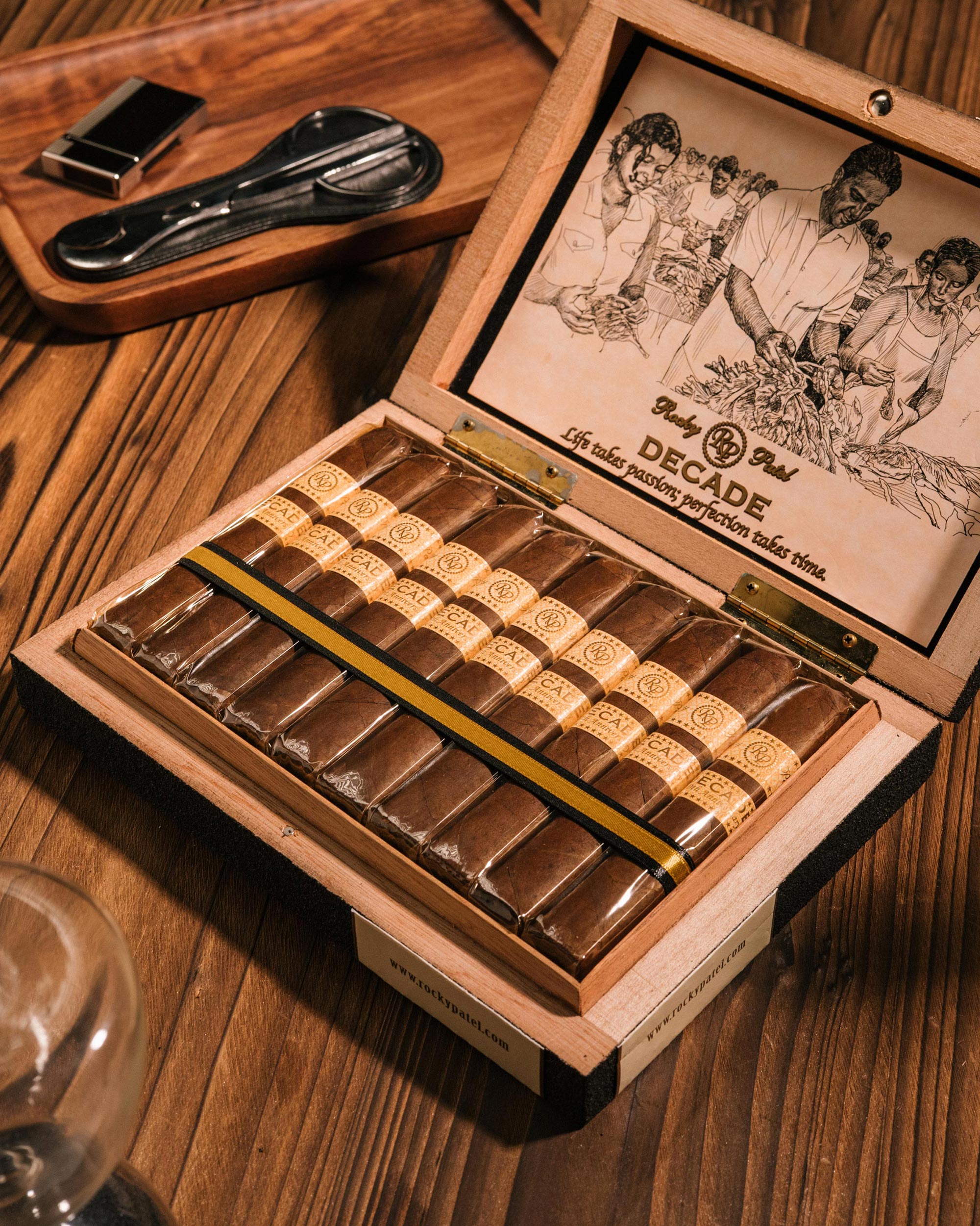 Open wooden humidor filled with cigars on a wooden surface.