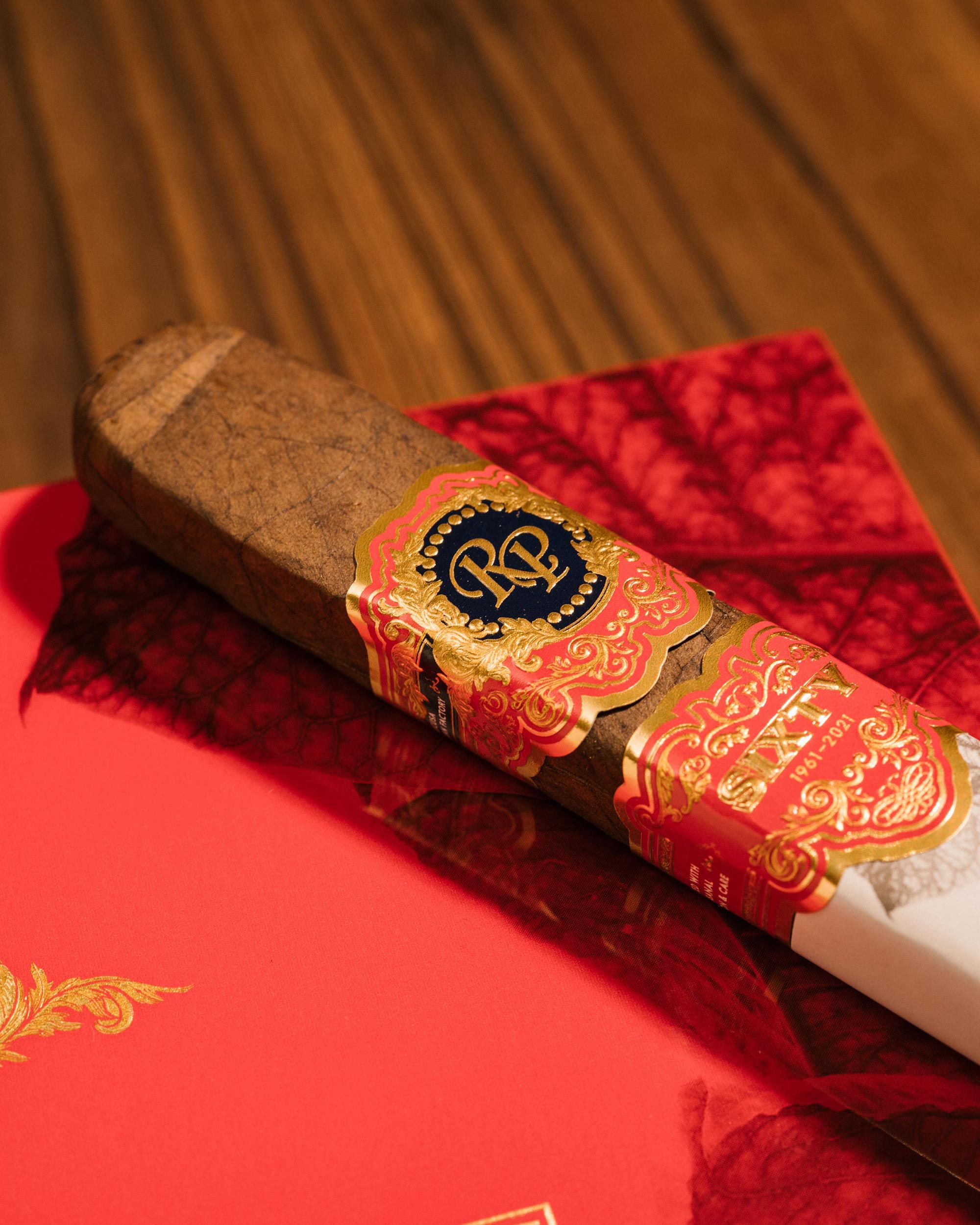 Cigar with decorative band on a red surface