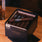 Box of Alec & Bradley Gatekeeper cigars on a wooden table with a glass of beer.