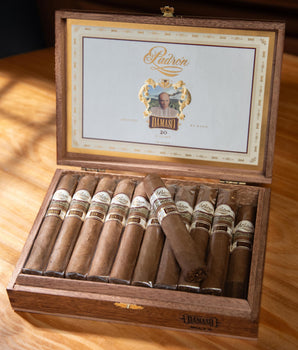 Open wooden box of Padron cigars on a wooden surface