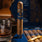 Cigar with blue wrapper on a wooden table next to a glass of whiskey