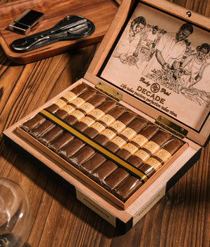 Open wooden humidor filled with cigars on a wooden surface.