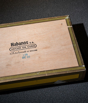 Wooden Habanos S.A. cigar box on a dark surface